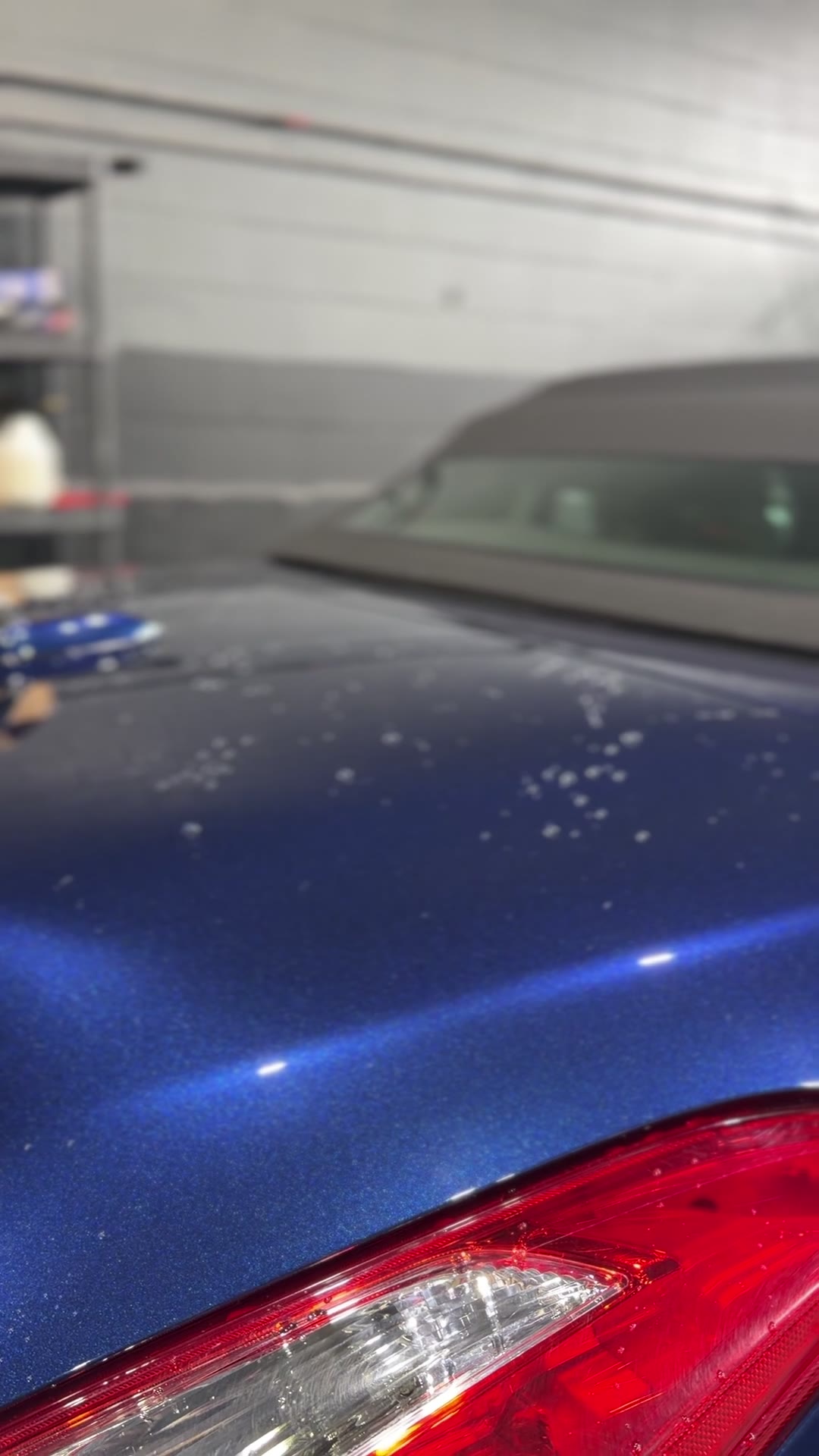 Blue Nissan convertible in the studio after ceramic coating, water beading on the rear panel.